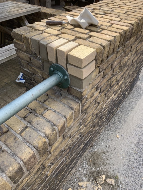 Nieuw metselwerk rond een stalen buis